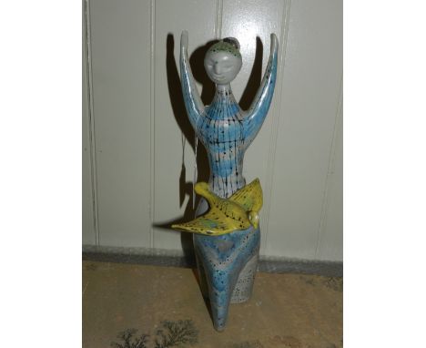 20th century Continental school. An unusual ceramic study of a woman with a bird. H: 29cm