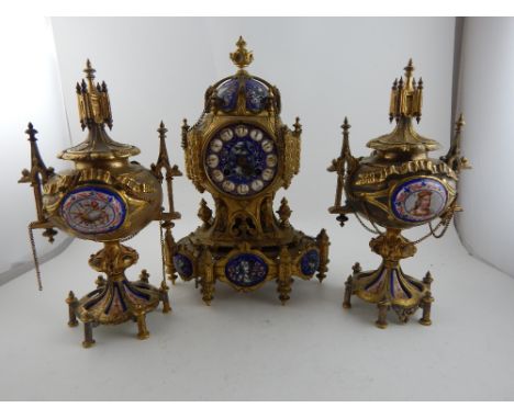 A mid 19th century French Gothic revival ormolu clock garniture, the clock of architectural form decorated with parcel gilt a