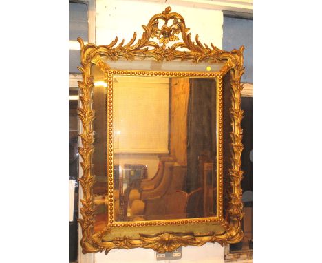 WALL MIRROR, late 19th century French giltwood and gesso, the cushion frame with frond border, beaded inner frame and bevelle
