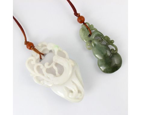 A Chinese green 'jade' pendant, the carved pendant with dragon shaped detail, 6cm long, with a further white 'jade' pendant, 