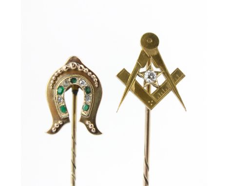 A late 19th century diamond stick pin, the stylised horse shoe head set with rose cut diamonds and mixed cut green stones, 8c