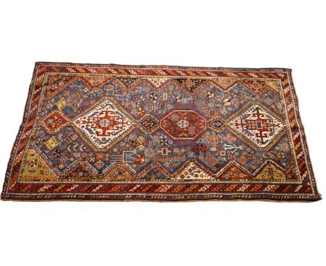 A Persian Heriz type hand knotted wool rug, the central blue ground with three linked octagonal medallions within an all over