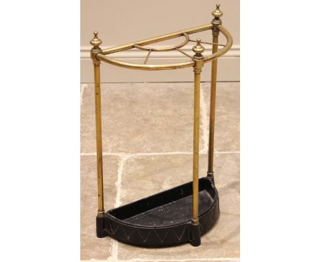 A lacquered brass and painted iron stick stand, early 20th century, of demi-lune form, urn shaped finials over five divisions