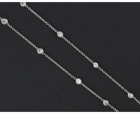 An early 20th century style diamond set chain, the nineteen brilliant cut diamonds spectacle set in white metal, with trace c