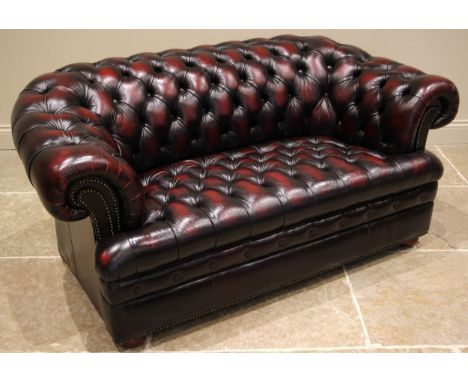 An ox blood red leather Chesterfield type two seater sofa, late 20th/early 21st century, of typical deep seated form, button 