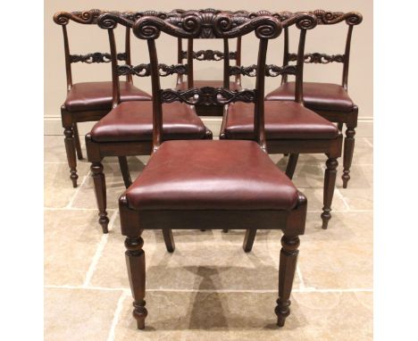 A set of seven George IV rosewood dining chairs, each with a carved scrolled crest rail over a conforming lower rail and a re