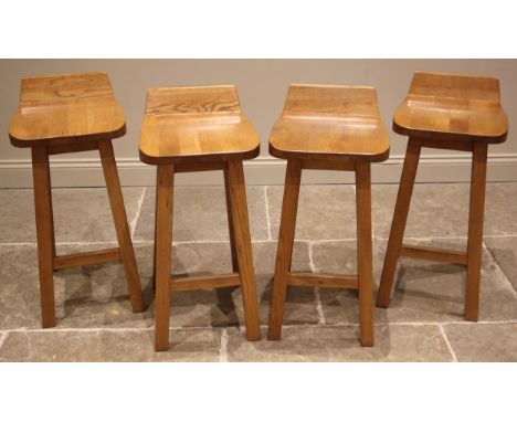A set of four contemporary light oak bar stools, each with a shaped seat extending to a raised back, upon substantial taperin
