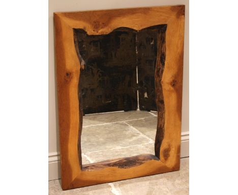 A contemporary light oak wall mirror, the rectangular mirrored plate within a rough-cut frame, 87cm x 64cm 