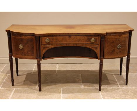 A Regency mahogany sideboard in the manner of Gillows, the shaped and inverted top outlined with stringing over a central con