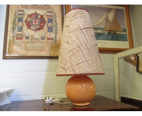 An orange coloured ceramic table lamp with shade