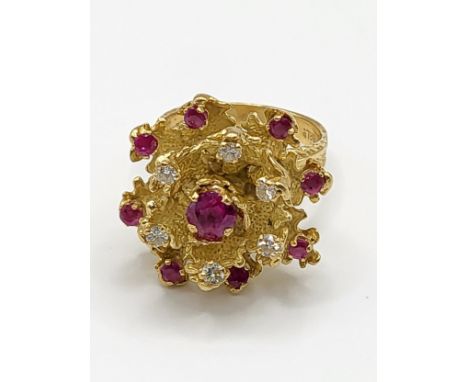 An 18ct yellow gold, diamond, and ruby cocktail ring, set with a rounded cushion-cut ruby measuring approximately 5 mm diamet