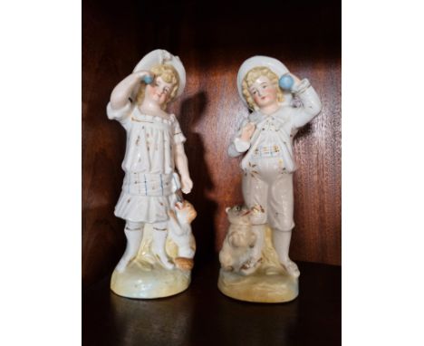 A pair of ceramic figures of a boy and girl 