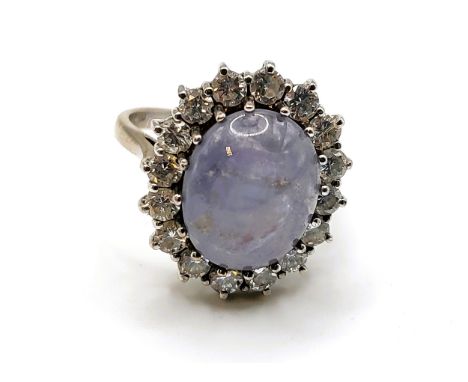 An 18ct white gold, diamond, and star sapphire ring, set with a pale blue cabochon sapphire, showing six point asterism, meas