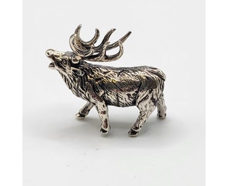 A novelty silver model of a stag, with textured body, marked 'sterling' to leg, 3.7 cm long, 2.8 cm high. 