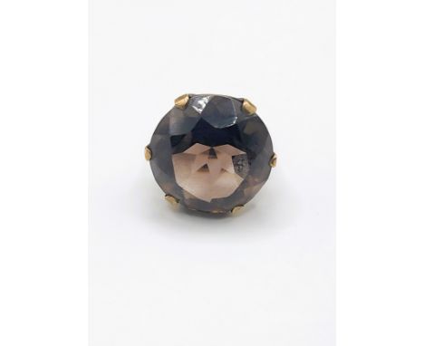 A 9ct yellow gold and smoky quartz cocktail ring, set with a large round-cut quartz, measuring approximately 2 cm diameter, s