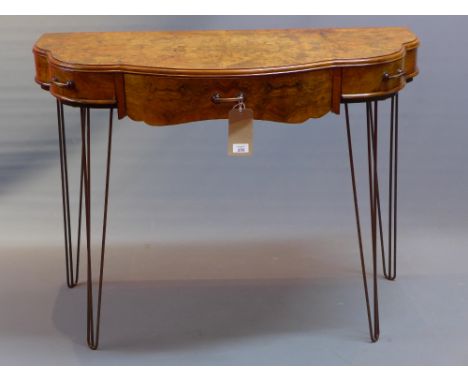 A contemporary console table having an Art Deco burr walnut top with three drawers and raised on steel spindle legs, H:82cm W