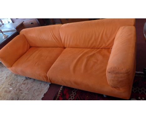 A contemporary three seater sofa having orange Alcantara removable covers and raised on steel legs. 