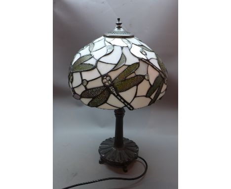 A Tiffany style lamp with stained lead glass shade decorated with dragonflies. 