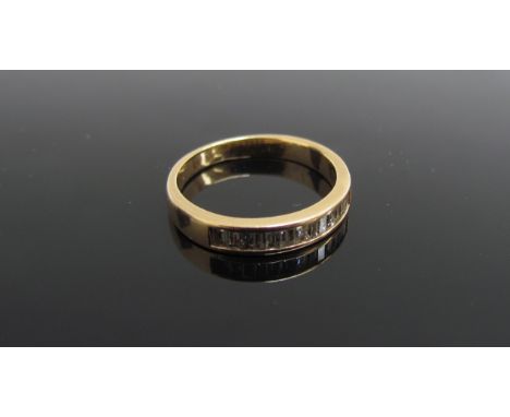 A gold ring channel set with baguette diamonds, stamped 14kj. Size H/I, 1.8g   