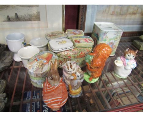 A quantity of Beatrix Potter items including four Beswick figures, tins and egg cups etc.