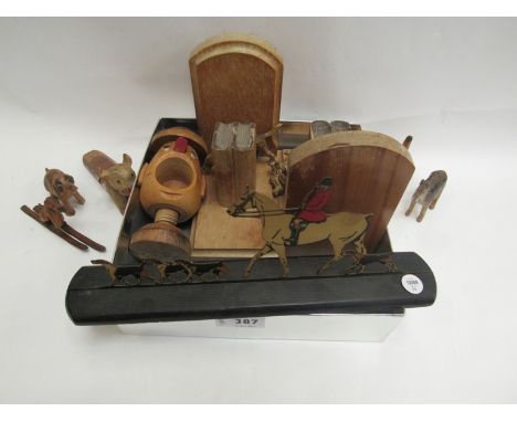 A collection of treen including book ends, door wedge, nutcracker and seven Black Forest style carved wooden dogs and hunting