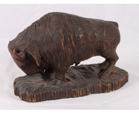 A Black Forest carved European bison, 12" long, and a continental carved figure of a man with an accordion stamped Rampp J, 1