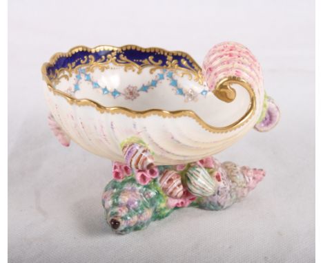 A Royal Worcester china sweetmeat dish moulded as a shell on shell decorated base, centre painted birds