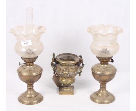 An Egyptian revival brass miniature urn together with two miniature brass oil lamps with glass shades, and a gilt metal lamp 