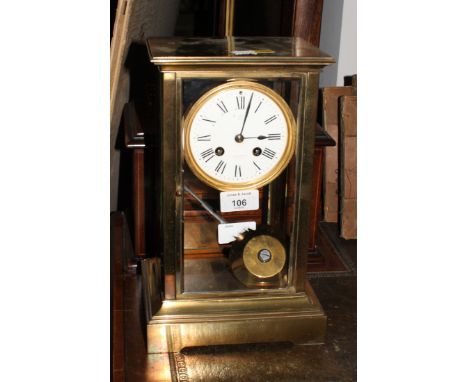 An early 20th Century brass framed mantel clock with bevelled glass sides, white enamel dial inscribed "W ANGUS PARIS", 12" h