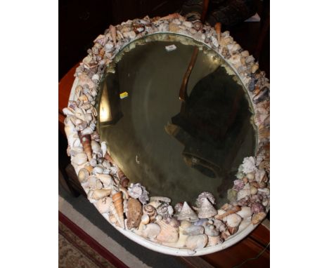 An oval bevelled wall mirror in white painted frame decorated sea shells, 36" x 24" and a shell encrusted table lamp base