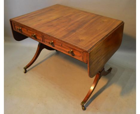 A Regency mahogany sofa table, with two frieze drawers opposed by dummy drawers raised upon twin end supports with turned str