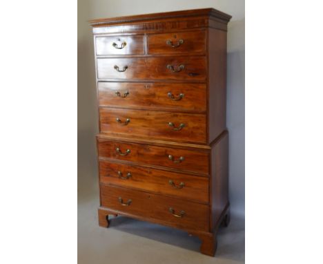 A George III Mahogany Chest on Chest, the moulded cornice above two short and six long drawers with brass handles, raised upo