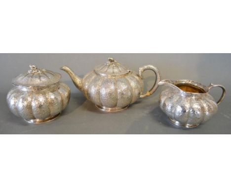 An Indian White Metal Three Piece Tea Service of Melon Form, comprising teapot, covered sucrier and cream jug, 38 ozs. 