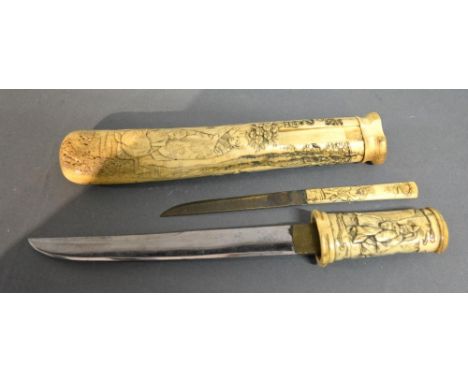 A Japanese Meiji Period Tanto with bone handle and scabbard decorated in relief with figures and bearing character mark, 28 c