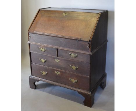An 18th Century Oak Bureau, the fall front enclosing a fitted interior with well above two short and two long drawers with br