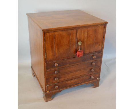 A 19th Century Mahogany Nightstand with two doors above four long drawers with knob handles raised upon bracket feet, 60 cms 