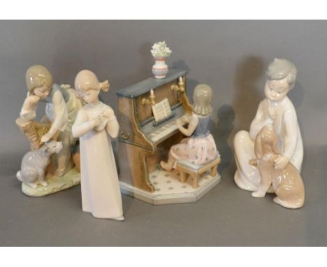 A Lladro Porcelain Model of a Girl Playing a Piano, together with three other similar Lladro Porcelain Figures 