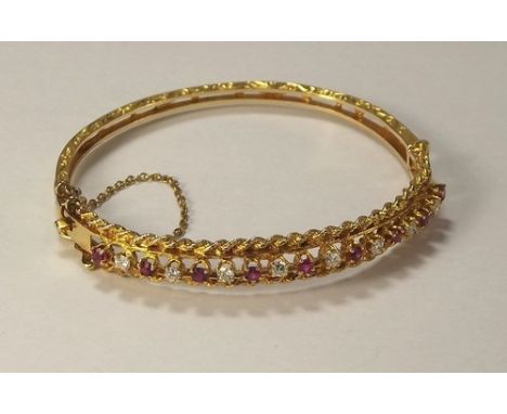 RUBY BANGLE.
A 9ct. gold ruby & diamond set bangle. 14g. CONDITION REPORTS: This bangle is in very good condition. There are 