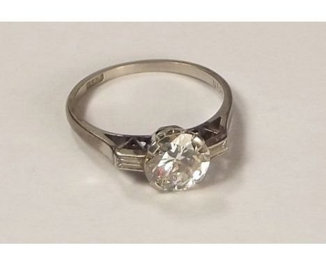 DIAMOND RING.
A platinum diamond ring, the central, brilliant cut stone of approx. 1.40ct. spread, flanked by two baguette cu