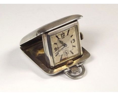 HANDBAG CLOCK.
An Art Deco, engine turned silver cased handbag travel clock, by SSM. Birmingham 1935. 4cm square.