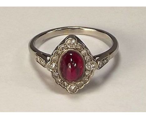 RUBY RING.
A platinum ring set a cabouchon oval ruby, within a diamond set border & shoulders. Size P/Q.