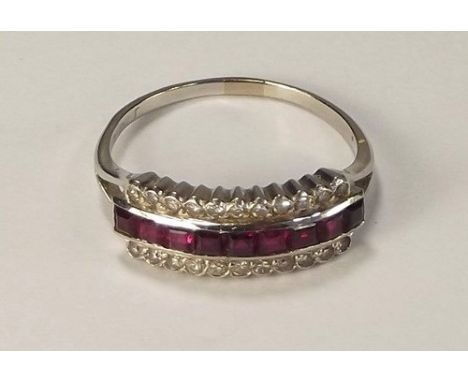 RUBY RING.
An Art Deco style platinum ring, set a row of nine square cut rubies within diamond borders. Size P/Q.