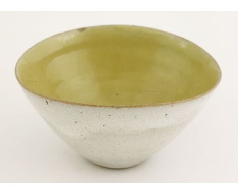 A stoneware bowl,by Lucie Rie (1902-1995), of slight pinched oval form, with a cream-grey glaze, the interior yellow-glazed, 