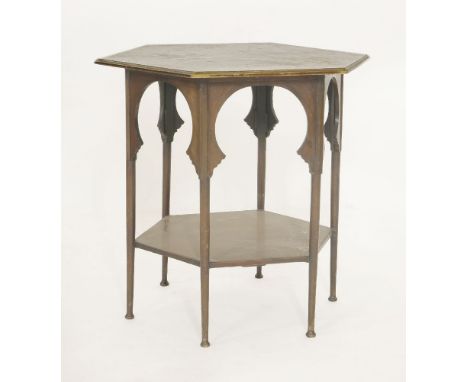 A mahogany hexagonal lamp table,in the style of E W Godwin, with an arched apron on six turned supports, with an undertier,70