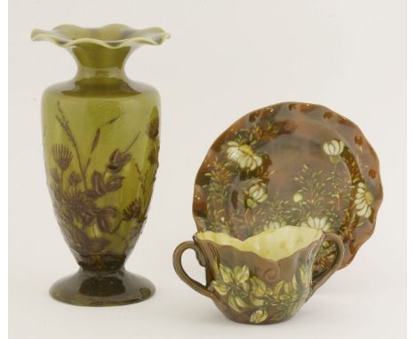 A Linthorpe Pottery vase,the urn-shaped body with a frilly rim with a mustard glaze, painted with brown flowers, impressed 'H