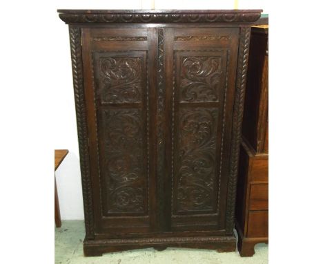 WARDROBE, Victorian oak, circa 1890, with a pair of carved panel doors enclosing a shelf, hooks and hanging rails, 198cm H x 