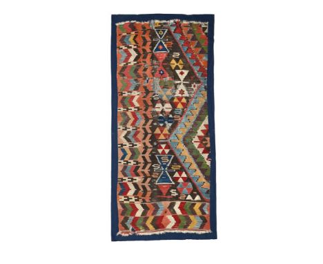 AN ANATOLIAN KILIM FRAGMENT FIRST HALF 19TH CENTURY Mounted on a navy linen backing the fragment 193 x 81cm including the bor