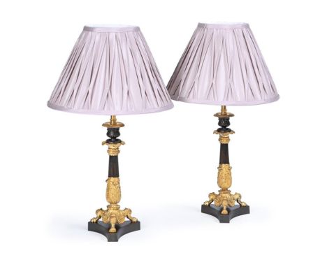 A PAIR OF FRENCH GILT AND PATINATED BRONZE LAMP BASES  CIRCA 1830 AND LATER  Now fitted, with pleated shades  28cm high to to