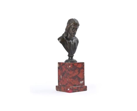 AN ITALIAN BRONZE BUST OF CHRIST  PROBABLY FLORENCE, 17TH CENTURY  Set on a red scagliola base  the bronze 9cm high,15.5cm hi