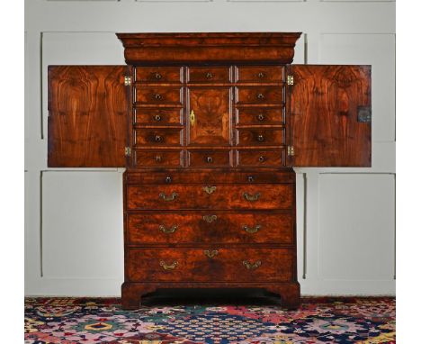 A GEORGE I BURR WALNUT AND WALNUT CABINET ON CHEST CIRCA 1720 The cabinet with a cushion drawer, the doors enclosing drawers,